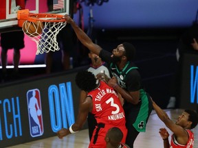 Boston Celtics guard Kemba Walker (top) dunks over Toronto Raptors forward OG Anunoby (3) during Ggame 5 Monday at ESPN Wide World of Sports Complex.