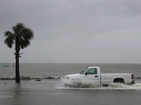 A driver navigates along a flooded road as the outer bands of Hurricane Sally come ashore on September 15, 2020 in Bayou La Batre, Alabama.