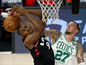 Raptors’ Serge Ibaka (left) is blocked by Celtics’ Daniel Theis during Game 4 on Saturday night in Lake Buena Vista, Fla.
