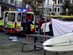 Emergency first responders attend to a surfer who was attacked by a shark at Greenmount Beach on Tuesday.