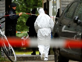 Police officers are seen at the entrance of a residential building where the bodies of five children were found in the western town of Solingen, Germany, September 3, 2020.