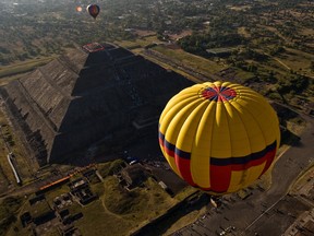 Hot air balloons fly over the Sun Pyramid in the Teotihuacan archaelogical site during the Teotihuacan Hot Air Balloon Festival in San Juan de Teotihuacan, State of Mexico, on March 21, 2010.
