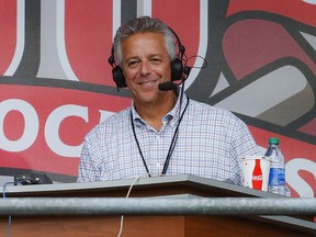 In this Sept. 25, 2019, file photo, Cincinnati Reds broadcaster Thom Brennaman sits in a special outside booth before the Reds' game against the Milwaukee Brewers in Cincinnati.