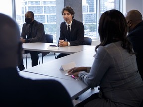 Prime Minister Justin Trudeau sits alongside HXOUSE co-founder Ahmed Ismail, as he meets with Black entrepreneurs at HXOUSE in Toronto, Wednesday, Sept. 9, 2020.