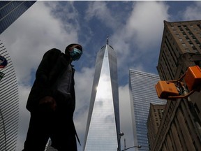 A man wearing a protective face mask walks by One World Trade Center two days before the 19th anniversary of the 9/11 attacks, amid the coronavirus disease (COVID-19) pandemic, in the lower section Manhattan, New York City, U.S., September 9, 2020.