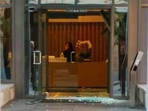 Smashed glass at a downtown condo building where a man used a hammer to shatter the doors.