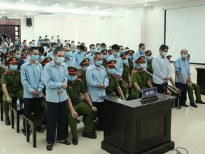 This picture taken and released by the Vietnam News Agency on September 14, 2020 shows defendants involved in a land dispute attending a court trial in Hanoi.