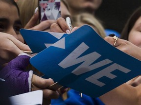 Fans get their sings autographed before the We Day event in Toronto, on Thursday, September 20, 2018.