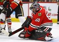Corey Crawford of the Chicago Blackhawks makes a save off of his mask against the Calgary Flames at the United Center on December 02, 2018 in Chicago, Illinois.