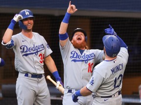 Max Muncy, right, of the Los Angeles Dodgers is congratulated by Cody Bellinger after hitting a grand slam home run against the Atlanta Braves during the first inning in Game 3 of the National League Championship Series at Globe Life Field on Oct. 14, 2020 in Arlington, Texas.