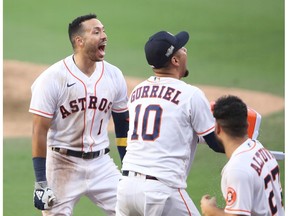 SAN DIEGO, CALIFORNIA - OCTOBER 15: Carlos Correa #1 of the Houston Astros is congratulated by Yuli Gurriel #10 after hitting a walk off solo home run to beat the Tampa Bay Rays 4-3 in Game Five of the American League Championship Series at PETCO Park on October 15, 2020 in San Diego, California.