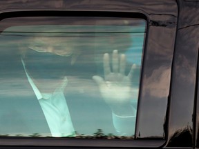 U.S. President Donald Trump waves to supporters as he briefly rides by in the presidential motorcade in front of Walter Reed National Military Medical Center, where he is being treated for COVID-19 in Bethesda, Md., Oct. 4, 2020.