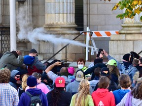 Law enforcement officers spray protesters shortly after a moment of silence during a Get Out The Vote march in Graham, N.C., Oct. 31, 2020.