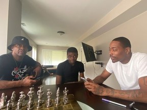 Chicago Outreach worker Bo Deal (L) talks with a gunshot victim Javell Gates, 17, and his father Jervelle Gates, 36, in their home in Chicago, Illinois, U.S., July 30, 2020.