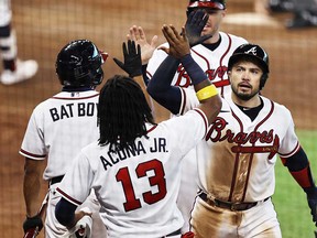 Travis d'Arnaud of the Atlanta Braves is congratulated by teammates after hitting a home run during the seventh inning against the Miami Marlins in Game 1 of the National League Division Series at Minute Maid Park on October 6, 2020 in Houston.
