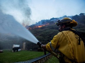 A firefighter battles the Blue Ridge Fire burning in Yorba Linda, Calif., Monday, Oct. 26, 2020.