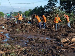 Employees of the Public Works Ministry remove debris blocking the road linking Nejapa and Quzaltepeque, El Salvador, after a landslide on October 30, 2020.