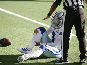 Dallas Cowboys quarterback Dak Prescott holds his leg after an injury in the third quarter against the New York Giants at AT&T Stadium.