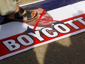 A man steps on a picture of French President Emmanuel Macron during a protest against cartoon publications of Prophet Mohammad in France and Macron's comments, in Karachi, Pakistan October 27, 2020.