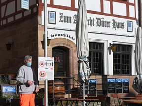An employee of the city sets up an information board on measures regarding the novel coronavirus in front of a restaurant in the city of Nuremberg, Germany, on October 28, 2020.