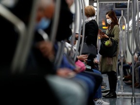 Passengers wearing protective face masks travel on a subway train as Italy adopts new restrictions aimed at curbing a surge in the coronavirus disease (COVID-19) infections, in Rome, Italy October 28, 2020.