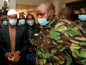 Mohamed Ahmed and Hussein Hassan are escorted by members of security forces after they were found guilty by Chief Magistrate Francis Andayi of helping al-Qaida-linked militants to launch an attack on the Westgate mall, at the Milimani Law Courts in Nairobi, Kenya Oct. 7, 2020.