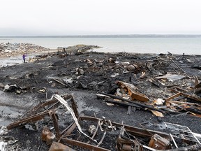 A person takes a photograph in the rubble of a fish facility in Middle West Pubnico, Nova Scotia, Saturday, October 17, 2020.