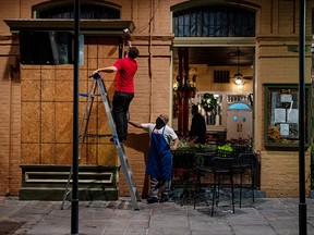 Pere Antoine Restaurant general manager Gaige Rodriguez, left, and Michael Dillon board up windows as they prepare for the arrival of tropical storm Zeta in New Orleans October 27, 2020.