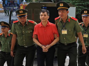 U.S. citizen Michael Nguyen is escorted by policemen before his trial at a court in Ho Chi Minh city, Vietnam June 24, 2019.