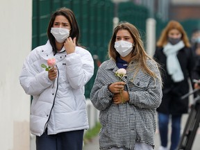 People bring flowers to the Bois d'Aulne college after the attack in the Paris suburb of Conflans St Honorine, France, October 17, 2020.