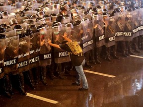 Anurak Jeantawanich, 52, pushes against police officers during an anti-government protest in Bangkok, Thailand, October 16, 2020.