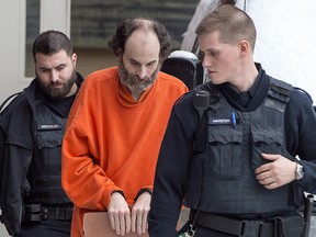 Matthew Raymond is escorted from provincial court in Fredericton on Friday, Feb. 8, 2019.