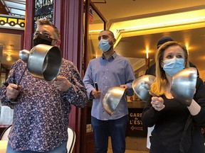 French restaurants workers, wearing black armbands and hitting pots, protest in front their restaurant La Ville de Provins in Paris October 2, 2020.