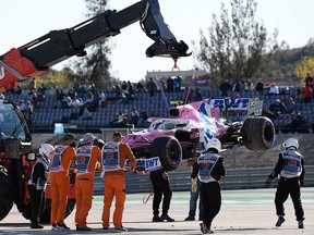 Marshals move the car of Racing Point's Canadian driver Lance Stroll after an accident during the second practice session at the Autodromo Internacional do Algarve on October 23, 2020 in Portimao.