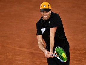 Sam Querrey of the U.S. returns the ball to Russia's Andrey Rublev during their men's singles first round match at the 2020 French Open in Paris, Sept. 29, 2020.
