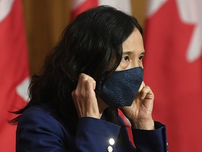 Chief Public Health Officer Theresa Tam removes her mask as she arrives for a news conference Friday, October 2, 2020 in Ottawa.