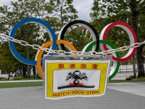 A warning notice flaps near the Olympic Rings on October 13, 2020 in Tokyo, Japan