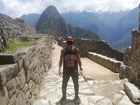 Japanese tourist Jesse Takamaya poses for a photograph during his visit to the ruins of Machu Picchu, Peru October 10, 2020.