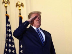 U.S. President Donald Trump salutes from the Truman Balcony upon his return to the White House from Walter Reed Medical Center, where he underwent treatment for COVID-19, in Washington, D.C., on Oct. 5, 2020.