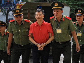 U.S. citizen Michael Nguyen is escorted by policemen before his trial at a court in Ho Chi Minh city, Vietnam June 24, 2019.