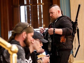 William Null (right) stands in the gallery of the Michigan Senate Chamber during the American Patriot Rally, organized by Michigan United for Liberty, to demand the reopening of businesses on the steps of the Michigan State Capitol in Lansing, Michigan, on April 30, 2020.