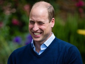 In this file photo taken on July 03, 2020, Britain's Prince William, Duke of Cambridge, smiles as he talks to the landlords and workers  at The Rose and Crown pub in Snettisham in eastern England.