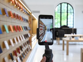 An Apple Store employee demonstrates an iPhone gimbal during the grand opening and media preview of the new Apple Carnegie Library store in Washington, U.S., May 9, 2019.