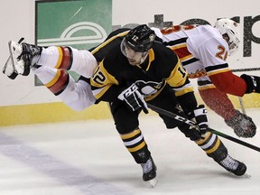 The Pittsburgh Penguins’ Dominik Simon collides with the Calgary Flames’ Michael Stone (26) during a game at PPG Paints Arena in Pittsburgh on Nov. 25, 2019.