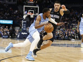 Minnesota Timberwolves' Malik Beasley, left, drives past Orlando Magic's Nikola Vucevic during a game, Friday, March 6, 2020 in Minneapolis.