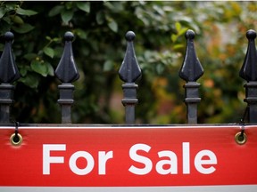 A real estate sign is seen hanging on a fence in front of a house for sale in Ottawa, Ontario, Canada, August 15, 2017.