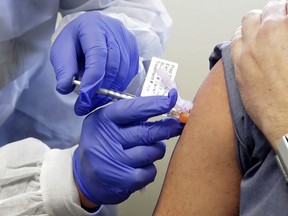 A subject receives a shot in the first-stage safety study clinical trial of a potential vaccine by Moderna for COVID-19 at the Kaiser Permanente Washington Health Research Institute in Seattle, March 16, 2020.