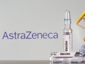 A test tube labeled with the vaccine is seen in front of AstraZeneca logo in this illustration taken, September 9, 2020.