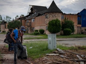 Jermaine Reed, 25, and Tehyanna Stevens, 21, pull their belongings past debris from Hurricane Laura as they evacuate their apartment complex ahead of Hurricane Delta in Lake Charles, Louisiana, Oct. 8, 2020.