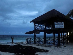 A man takes a video with his phone at a beach as Hurricane Delta approaches Cancun, Mexico, Oct. 6, 2020.